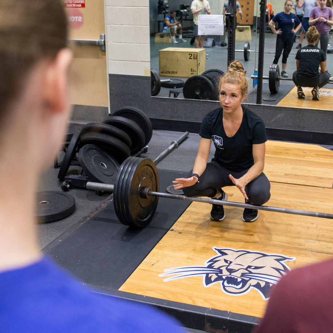 Personal Trainer Instructing Learn To Lift