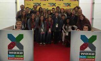 Students posing with SXSW signs