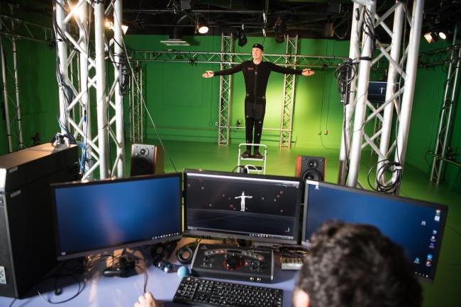 Student in front of a green screen in the GRID lab